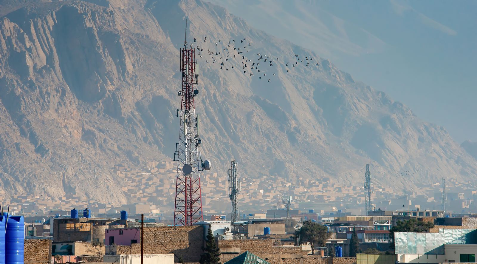 Telcom tower above the city, with mountains behind